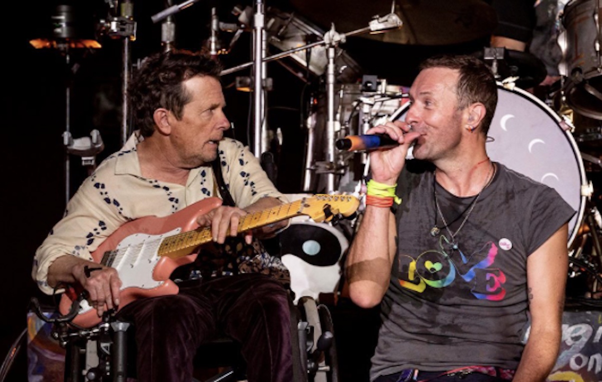 Glastonbury, Michael J. Fox sul palco con i Coldplay: ha suonato la chitarra in ‘Fix You’
